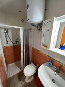 a bathroom with a toilet and a sink and a shower at Verde Mare in Trapani