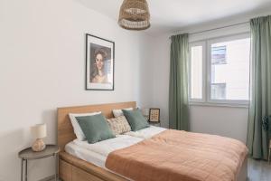 - une chambre avec un lit doté de rideaux verts et d'une fenêtre dans l'établissement Corvin apartment, à Budapest