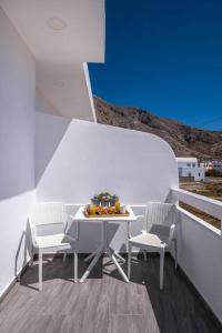 a white table and chairs on a balcony at Perissa Secret in Perissa