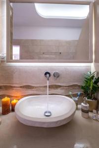 a white sink in a bathroom with a mirror at Perissa Secret in Perissa
