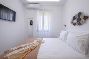 a bedroom with a white bed with a hat on it at Perissa Secret in Perissa