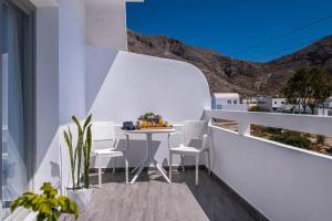 a white balcony with a table and chairs at Perissa Secret in Perissa