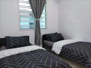a bedroom with two beds and a couch and a window at Homestay 88A Melaka for 9 pax with Smart TV and Netflix and wifi in Melaka