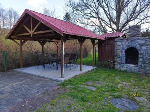 a pavilion with a table and chairs and a stone oven at Jaskółka in Lądek-Zdrój
