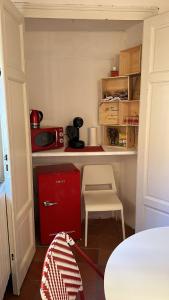 a small kitchen with a red cabinet and a table at San Giorgino Home in Florence