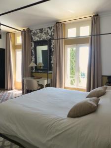 - une chambre avec un grand lit blanc et une fenêtre dans l'établissement Hostellerie du Château des Fines Roches, à Châteauneuf-du-Pape