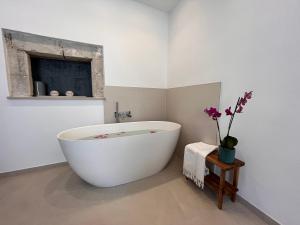 a white bath tub in a bathroom with a window at Aglaia apartment residence delle tre grazie in Syracuse