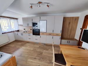 a kitchen with white cabinets and a wooden floor at Malostranská restaurace in Lišov