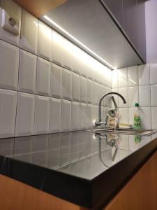 a kitchen counter with a sink and a mirror at Schnucki Studio - JP Apartment in Kedungbadak