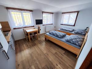 1 dormitorio con 2 camas, mesa y cocina en Malostranská restaurace, en Lišov