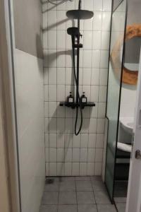 a shower with a hose in a bathroom at Schnucki Studio - JP Apartment in Kedungbadak