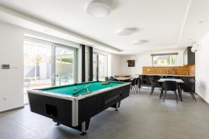 a room with a pool table and some chairs at PARK Apartmanok in Balatonszárszó
