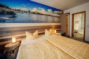 a bedroom with a bed and a painting of a lake at Hotel-Pension Hafemann in Senftenberg