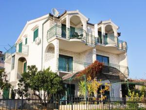 a white building with balconies and a fence at Apartment M in Seget Vranjica