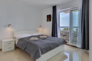 a bedroom with a bed and a large window at Villa Stjepanovic in Tribanj-Krušćica