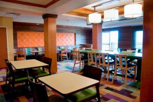 a dining room with tables and chairs and windows at Fairfield Inn & Suites Ames in Ames