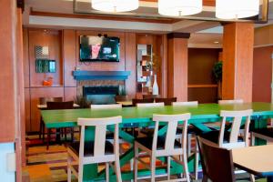 a dining room with a green table and chairs at Fairfield Inn & Suites Ames in Ames