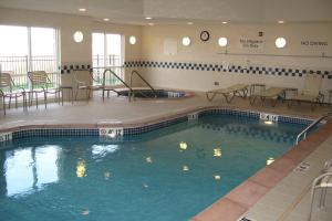 a large swimming pool with chairs and tables in a building at Fairfield Inn & Suites Ames in Ames
