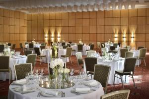 un salón de banquetes con mesas y sillas blancas en Accra Marriott Hotel en Accra