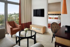 a hotel room with a bed and a desk and a table at Accra Marriott Hotel in Accra