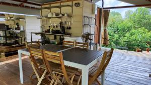 a dining room with a table and chairs on a deck at Canopy Villa Sireh Park in Johor Bahru