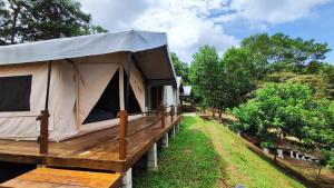 a tent with a wooden deck in a field at Canopy Villa Sireh Park in Johor Bahru
