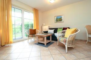 Una sala de estar con un sofá y sillas y una mesa. en Altes Wasserwerk App 03, en Wustrow