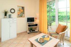 Una sala de estar con un sofá y un televisor en Altes Wasserwerk App 03, en Wustrow