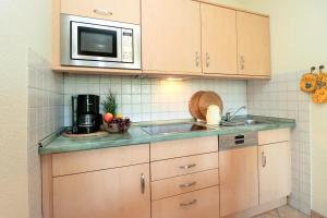 a kitchen with a sink and a microwave at Altes Wasserwerk App 03 in Wustrow +4 photos