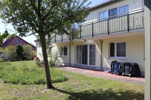 a house with two chairs on a patio at Altes Wasserwerk App 09 in Wustrow