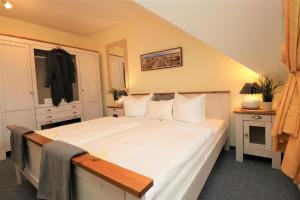 Un dormitorio con una gran cama blanca con almohadas blancas. en Altes Wasserwerk App 14, en Wustrow