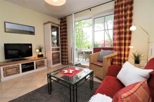 Una sala de estar con un sofá y un televisor en Altes Wasserwerk App 14, en Wustrow