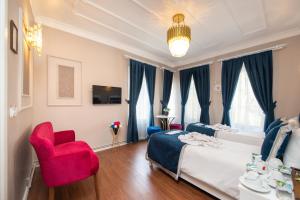 ein Schlafzimmer mit einem Bett und einem roten Stuhl in der Unterkunft Begonville Corner in Istanbul