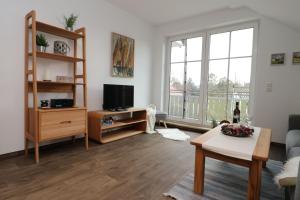a living room with a couch and a tv at Altes Wasserwerk App 21 in Wustrow