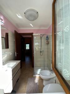 La salle de bains est pourvue de toilettes, d'un lavabo et d'une douche. dans l'établissement Villa Matilde, à Catabbio
