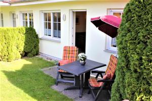 a table and chairs with an umbrella in a yard at Wohnpark Schmiedestraße App 15 in Wustrow