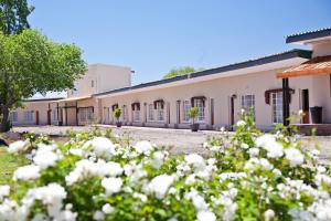 a building with white flowers in front of it at Wagon Wheel Country Lodge in Beaufort West