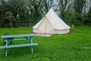 a tent and a picnic table in a yard at Japanese tent Secret garden glamping in Newark upon Trent
