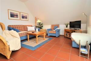 a living room with a couch and a tv at Haus Clarissa, App 02 in Wustrow