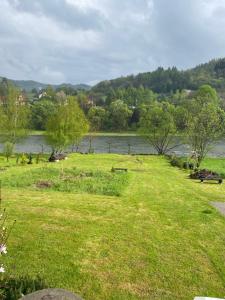 a field of grass next to a body of water at Biały Domek in Tylmanowa