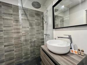 uma casa de banho com um lavatório e uma cabina de duche em vidro. em T2 Hyper Centre em Toulouse
