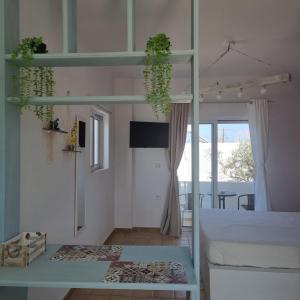 una camera con un letto e un tavolo con piante di Arocaria - Faliraki peaceful apartments a Faliraki