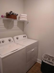 uma máquina de lavar roupa branca numa lavandaria com uma cesta em "OneKey" Luxury Apt - POOL - 4 Mi to Beach em Daytona Beach
