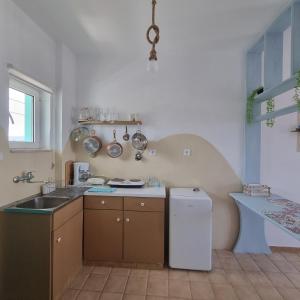 een keuken met een wastafel en een koelkast bij Arocaria - Faliraki peaceful apartments in Faliraki