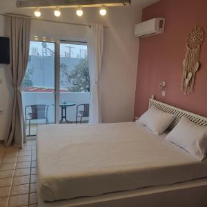 - une chambre avec un grand lit et un balcon dans l'établissement Arocaria - Faliraki peaceful apartments, à Faliraki