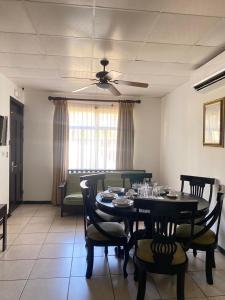 une salle à manger avec une table, des chaises et un ventilateur de plafond dans l'établissement Nacazcol - Playas del Coco, à Coco