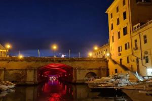 a bridge over a river at night with boats in the water at Casa Medicea sul canale in Livorno