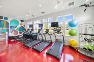 a gym with a row of treadmills and exercise equipment at "OneKey" Luxury Apt - POOL - 4 Mi to Beach in Daytona Beach