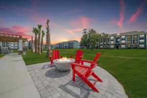 a group of red chairs sitting around a fire pit at "OneKey" Luxury Apt - POOL - 4 Mi to Beach in Daytona Beach