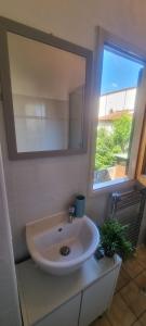 uma casa de banho com um lavatório, um espelho e uma janela em Casa Leonardo & Elisa em Figline Valdarno